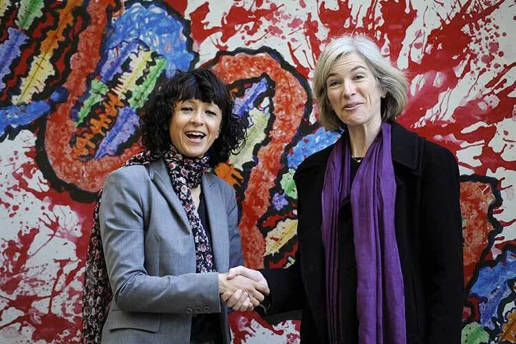 Two middle aged women smiling while greeting each other