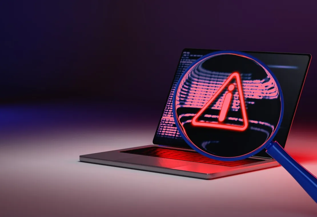 Laptop with a magnifying glass showing alert