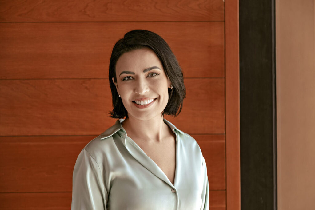 Woman wearing a beige silk blouse smiling