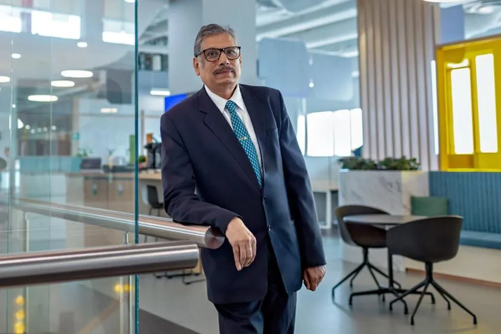 Man with a moustache and reading glasses, with a blue suit