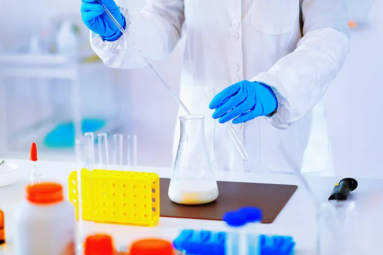 Photograph of a scientist in a white robe working at a laboratory