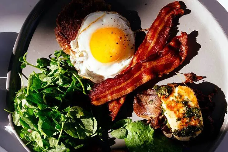 Image of a plate with proteins: egg, bacon and fish.