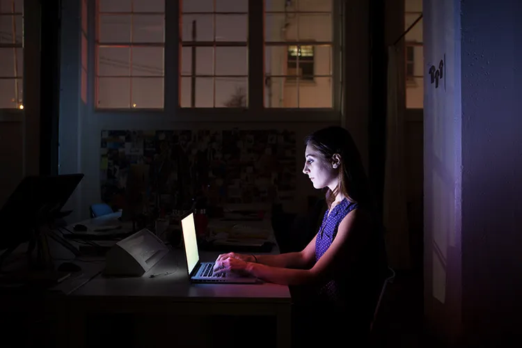 a woman works at night in her computer