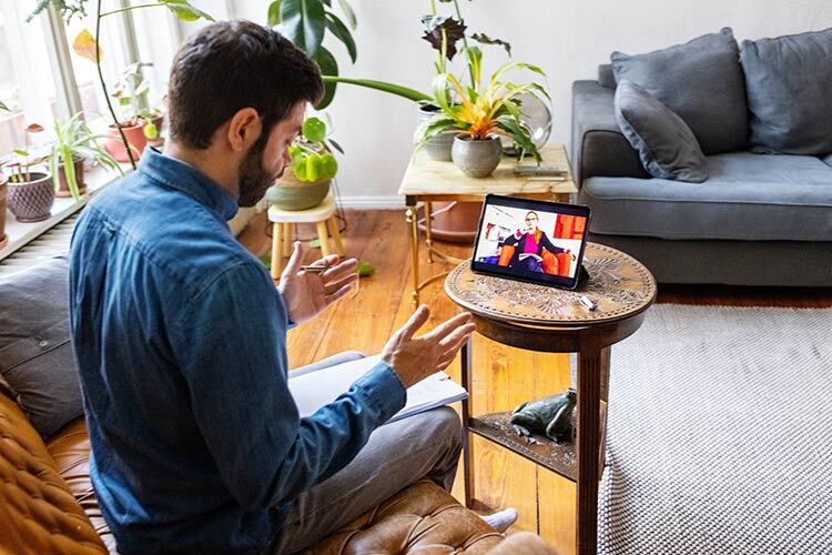 photograph of a male bearded person taking online therapy while sitting at home telemedicine