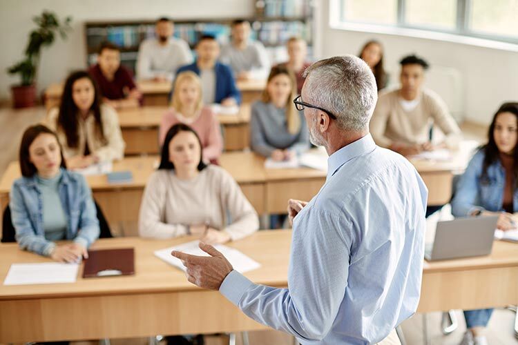 a gray haired man as professor teaching a class