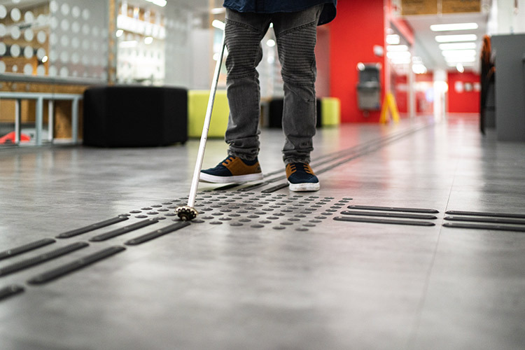 Photograph of a person using a cane for the blind