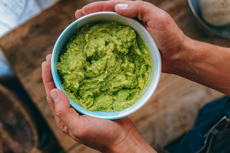 A bowl of guacamole on a table.