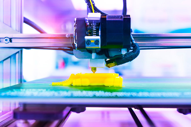 photograph of a 3D printer printing something yellow