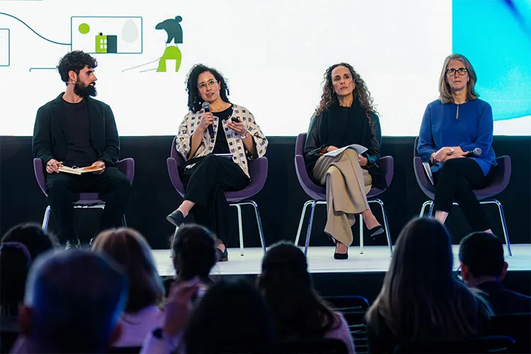 Photograph of a man and three women sitting on a stage arguing