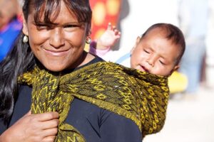 Indigenous woman carrying a baby