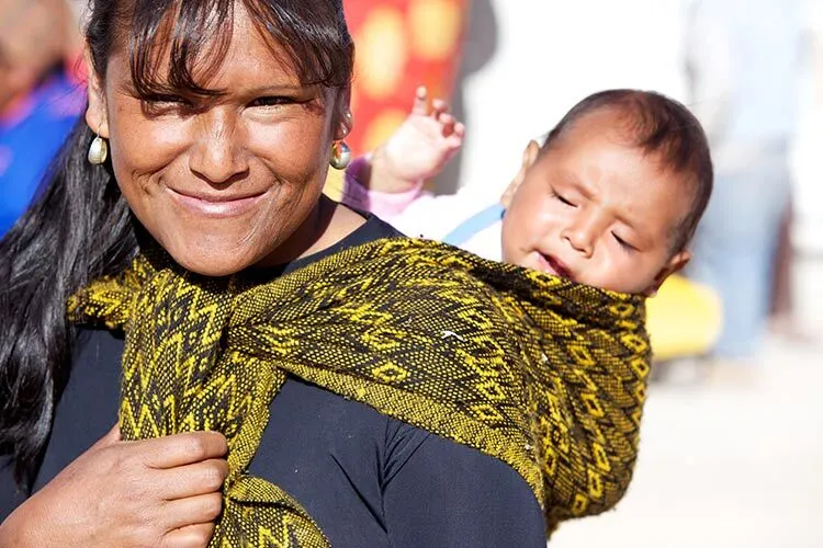 Indigenous woman carrying a baby