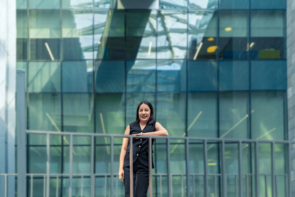Photograph of a woman standing on a blue building