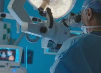 Photograph of a surgeon looking through a robotic microscope