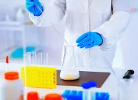Photograph of a scientist in a white robe working at a laboratory