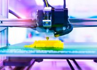 photograph of a 3D printer printing something yellow