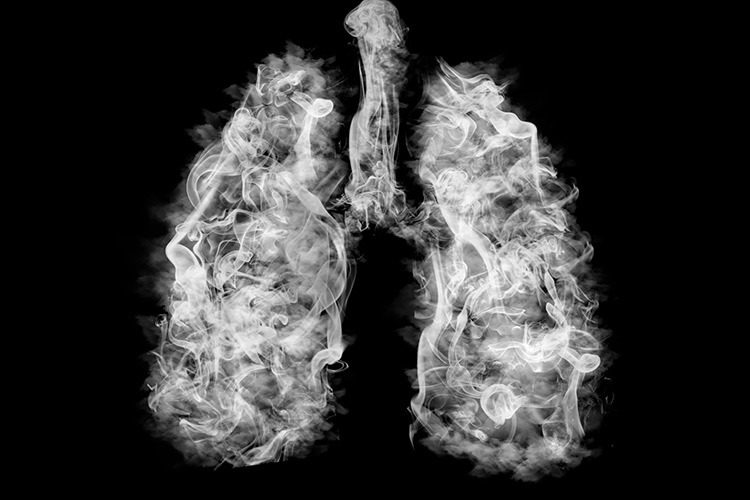 Black and white illustration of two lungs filled with smoke