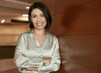 Woman with a nice beige blouse, smiling and crossing arms