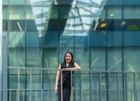 Photograph of a woman standing on a blue building