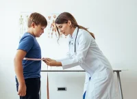 image of a person with a tapemeter sizing a child waste