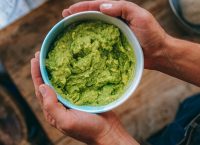 A bowl of guacamole on a table.