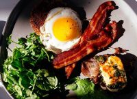 Image of a plate with proteins: egg, bacon and fish.