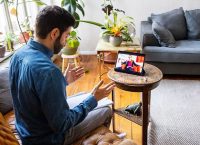 photograph of a male bearded person taking online therapy while sitting at home telemedicine