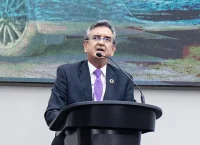 Gray-haired man wearing suit at presentation podium