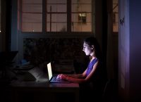 a woman works at night in her computer