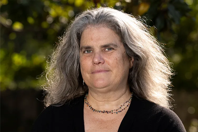 mujer adulta con cabello suelto canoso viendo a la cámara