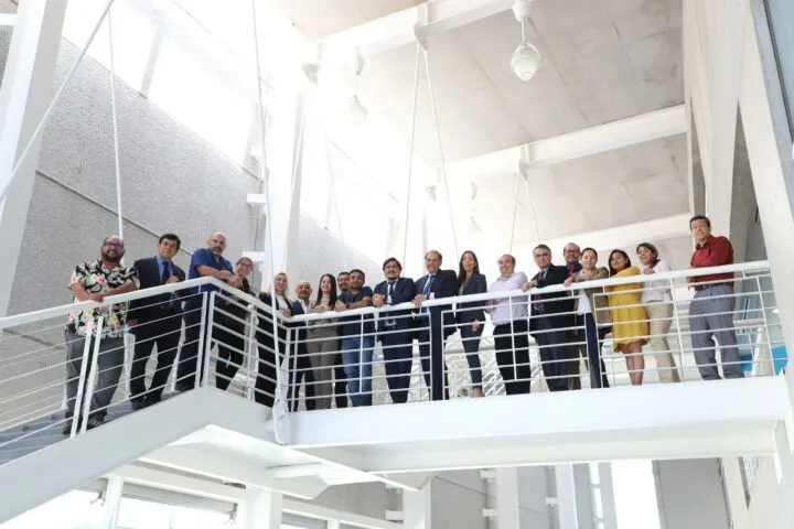 Varias personas recargadas en el barandal de una escalera