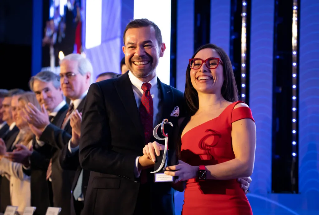 Una mujer y un hombre ganando un premio