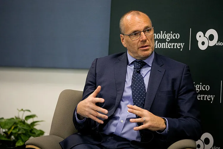 Hombre habla sentado en una silla