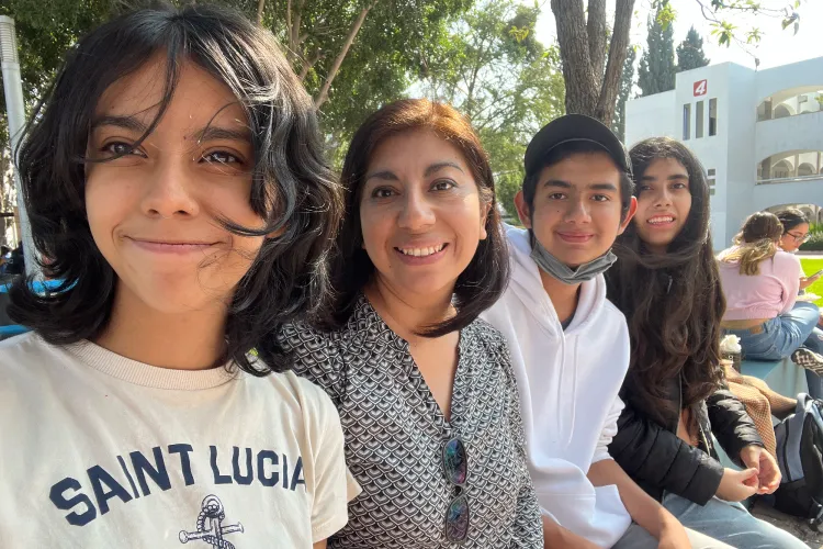 Mujer sentada en medio de sus tres hijos