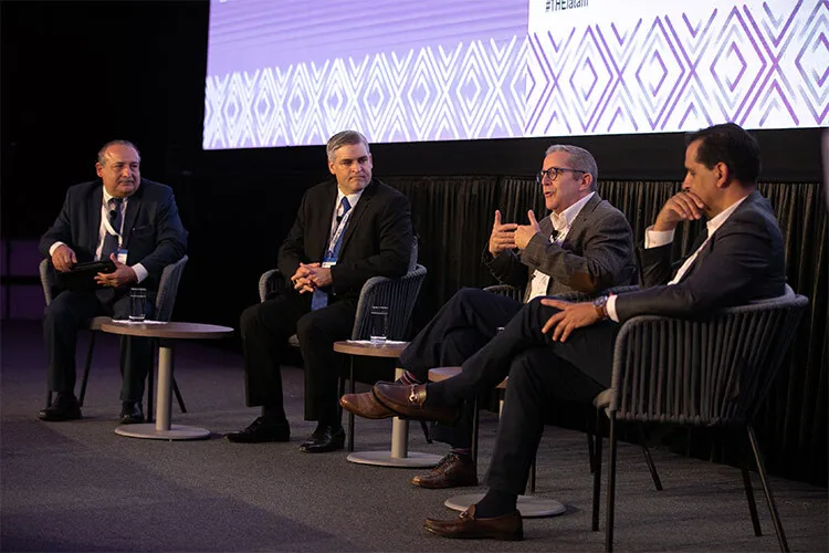 Cuatro hombres hablan sentados en sillas