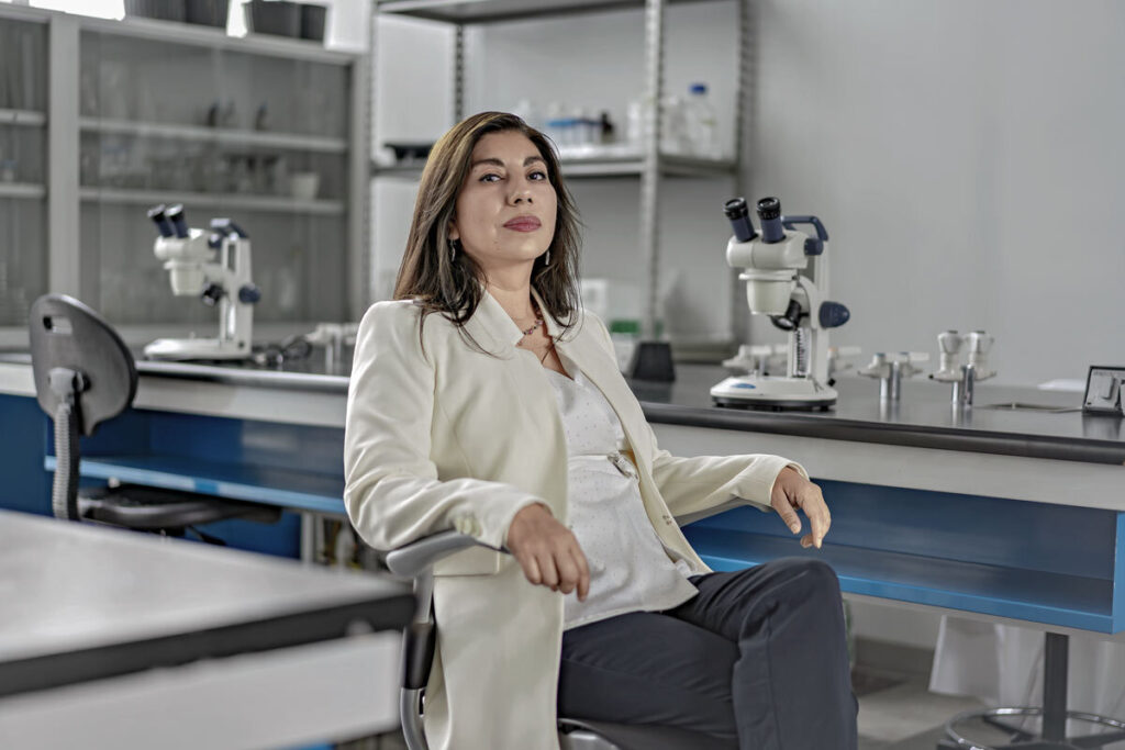 Investigadora sentada en un laboratorio. No trae bata