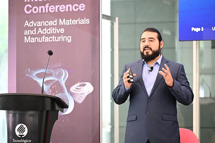 hombre hablando frente a un escenario, dando una conferencia