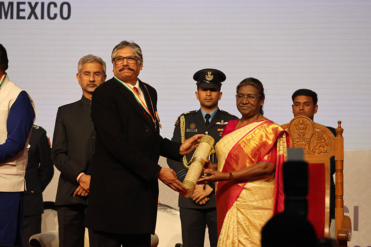 Hombre recibiendo un premio de las manos de la presidenta de la India