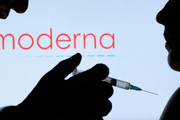 imagen de una persona inyectando a otra en fondo negro con una jeringa en la mano y el logo del laboratorio moderna de fondo