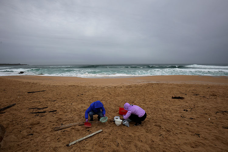 imagen de dos mujeres limpiando las playas de españa
