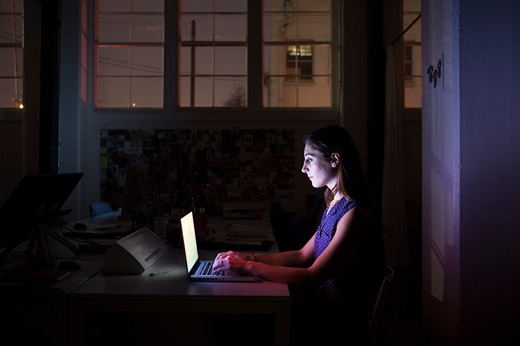 mujer trabaja en computadora por la noche