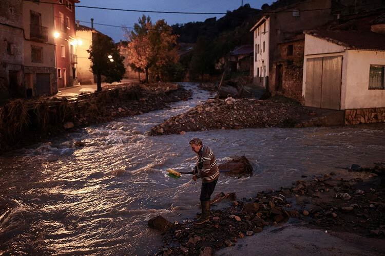 Un hombre mayor termina de limpiar su casa después de la inundación devastadora provocada por lluvias intensas en la provincia de Teruel, España. (Fotografía: Reuters).