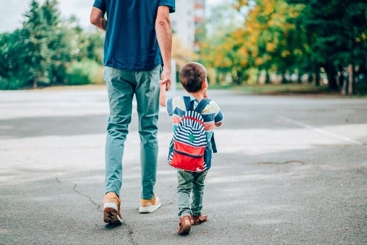 imagen de un padre llevando de la mano a un niño