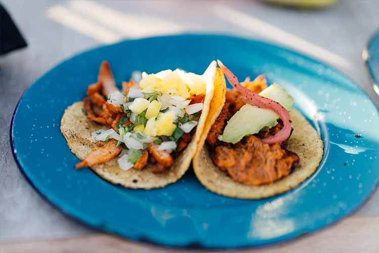 imagen de unos tacos de pastor a la mexicana con piña en un plato azul