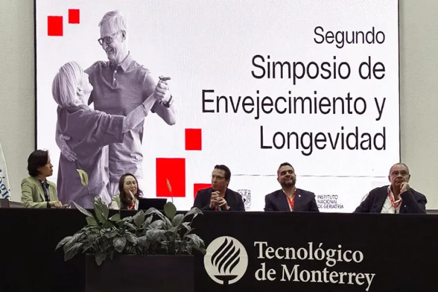 fotografía de dos mujeres y tres hombres sentados en una mesa durante el simposio de envejecimiento y longevidad
