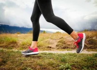 Foto donde se ven las piernas de una mujer corriendo en el campo