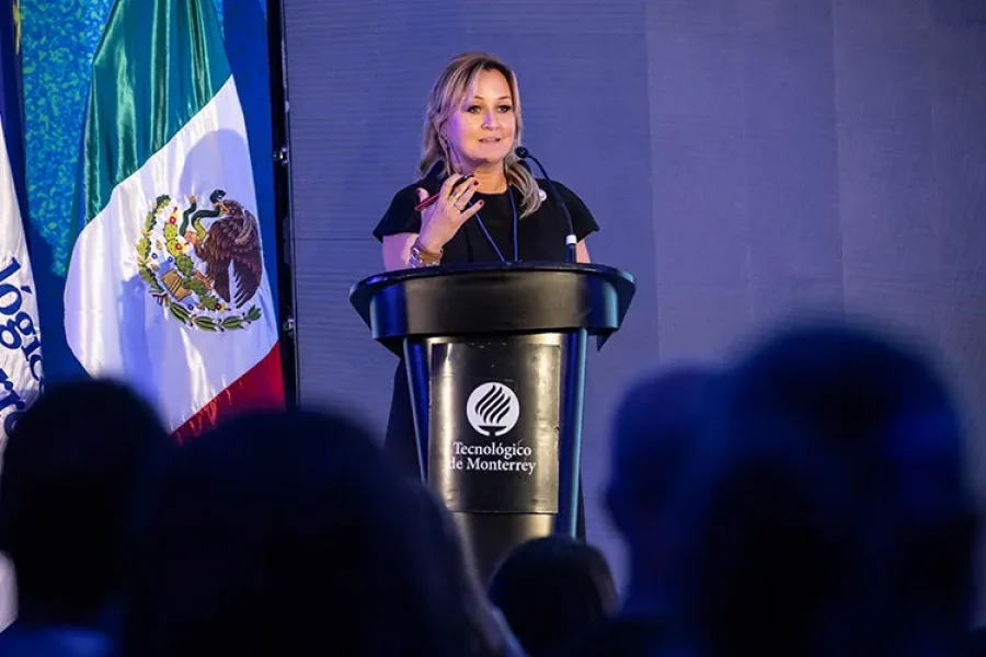 foto de una mujer, Angélica Pongutá, en un podio hablando en un micófono