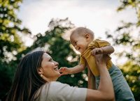 Fotografía de una madre sujetando a su bebé y sonriendo