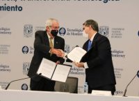 Dos hombres de edad mediana, vistiendo traje, se saludan