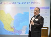 Especialista en tema del agua explica una presentación sobre este tema proyectada con un mapa de México detrás de él.