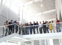 Varias personas recargadas en el barandal de una escalera